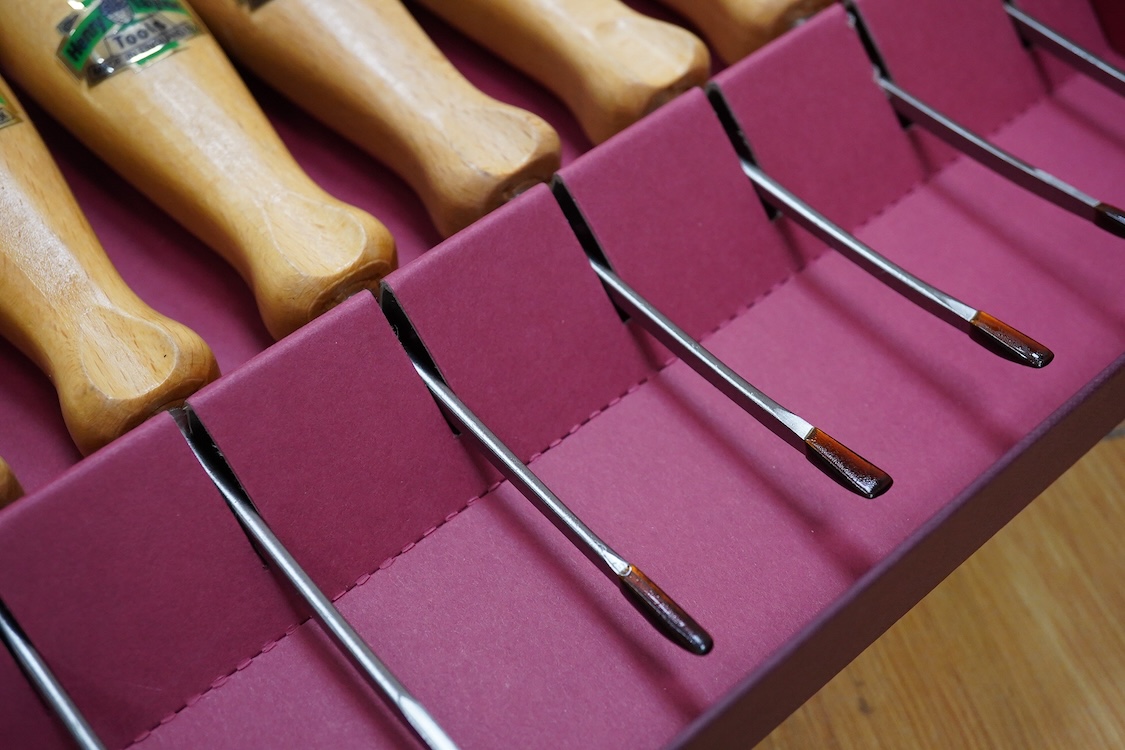 Three sets of Henry Taylor Tools Limited of Sheffield, wood carving chisels, comprising of a 12-carving chisel set contained within a fitted beech case, a set of 17 skew gouges in a fitted card case, and a set of 12 micr